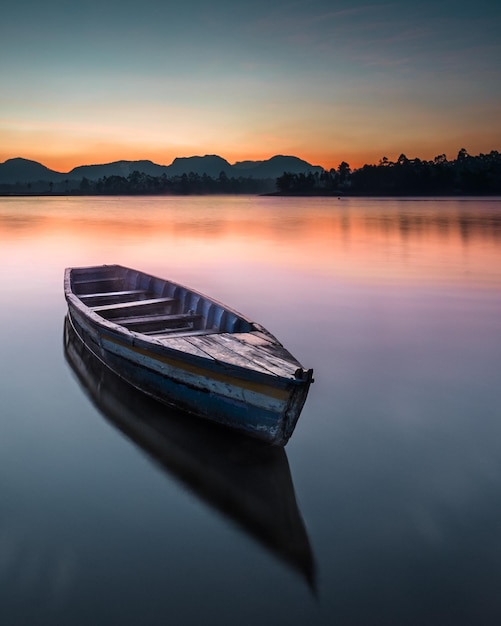 Barco amarrado en el lago contra el cielo durante la puesta de sol