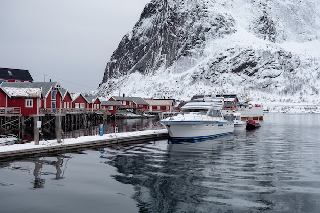 Barco ancorado no cais com vila de pescadores em lofoten