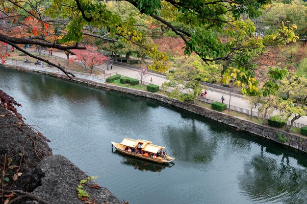 Barco antiguo dorado navegando en el río en el jardín de otoño