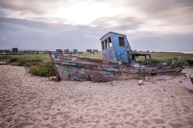 Barco en la arena en el muelle sobre pilotes del tradicional pueblo pesquero de Carrasqueira en Portugal