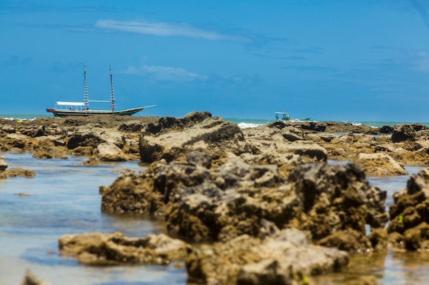 barco atrás de um recife em uma praia brasileira