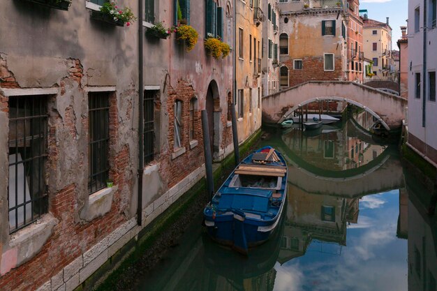 Un barco azul está atracado en un canal de Venecia.