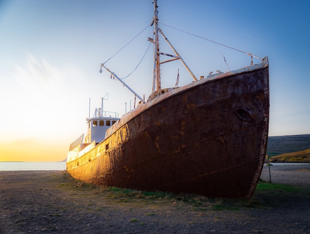 Un barco ballenero apartado que naufragó en la playa de Latrabjarg durante la puesta de sol.