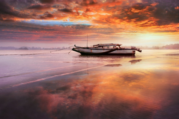 barco de belleza en la mañana con increíble cielo amanecer