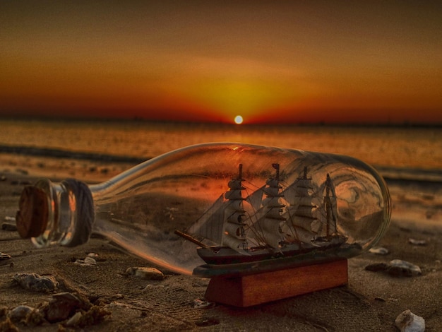 Foto un barco en una botella en una playa.