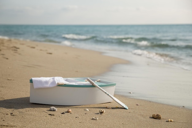 Barco branco com a pá na praia do oceano de areia na hora do nascer do sol De manhã cedo na costa do mar