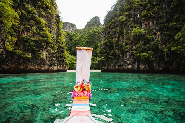 Barco de cola larga flotando en aguas transparentes de la isla phi-phi, la bahía maya, la isla paradisíaca en thailandia.