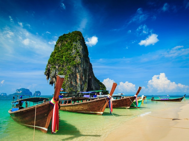 Foto barco de cola larga en una playa tropical con roca calcárea krabi tailandia