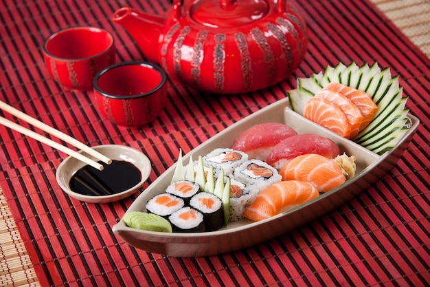 Barco de composición de sushi en superficie roja