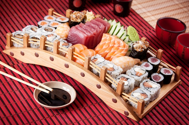 Barco de composición de sushi en superficie roja