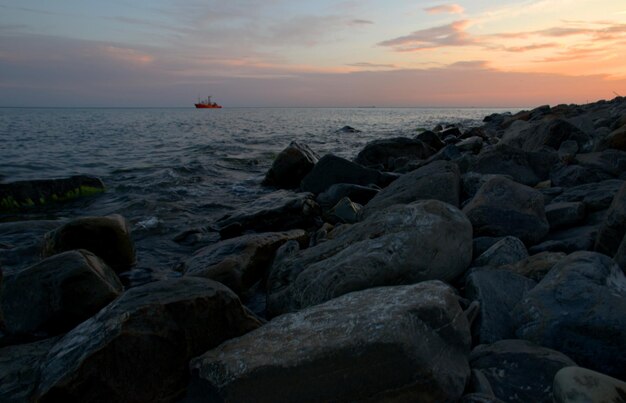 El barco contra el fondo de nubes rosadas al atardecer navega sobre las olas Noche de verano Hermoso paisaje de cuento de hadas Mar Negro Rusia