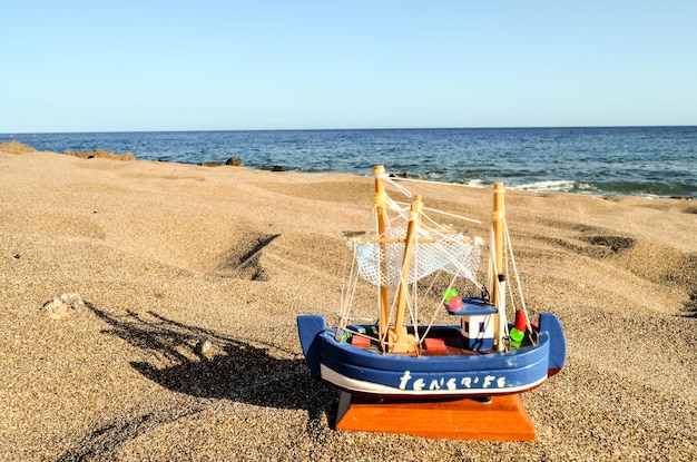 Barco de brinquedo na praia de areia