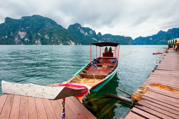 Foto barco de cauda longa flutuando no lago da ásia e homestay no entre as ilhas.