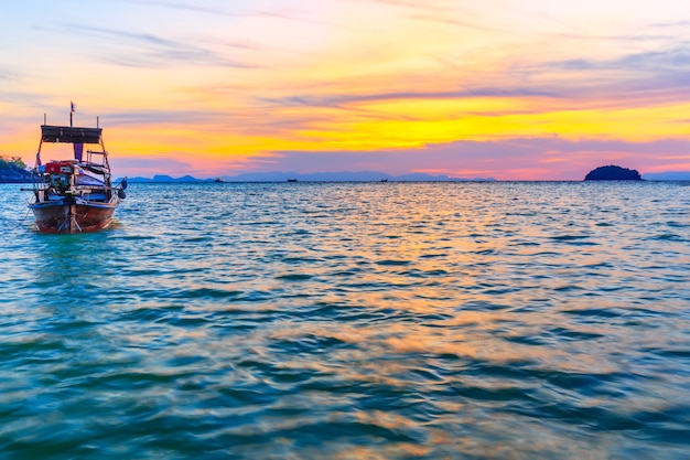 Foto barco de cauda longa na praia de areia de manhã na ilha tropical na tailândia