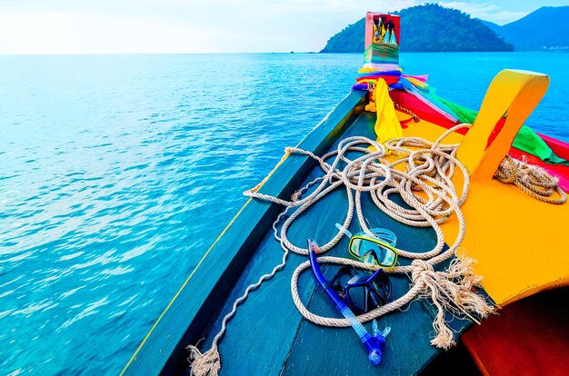 Barco de excursão tailandês em uma viagem marítima, máscara e óculos de proteção para mergulho na popa