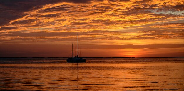 Barco de iate viajando de verão na água ao pôr do sol veleiros na água do mar oceano