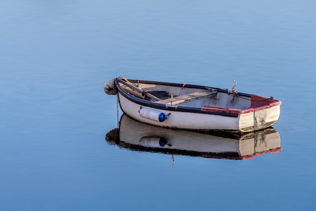 Barco de pesca de madeira branco em um mar calmo