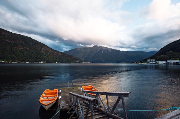 Barco de pesca em um lago imóvel na Noruega Barco em lago com água cristalina no fundo das montanhas