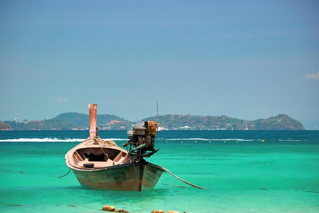 Barco de pesca na baía do mar tropical em um espaço de cópia à noite ensolarada