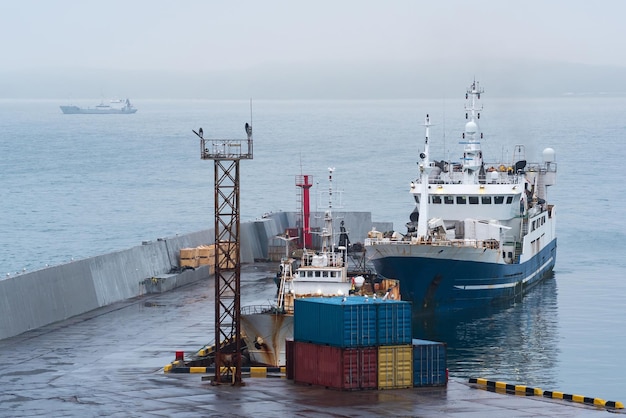 Barco de pesca no cais no porto na costa de um mar nublado