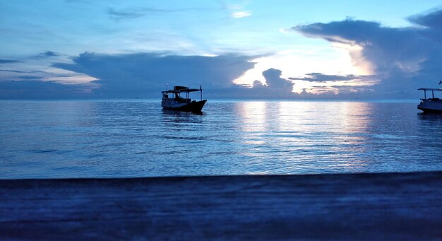 Foto barco de pesca no mar ao pôr-do-sol
