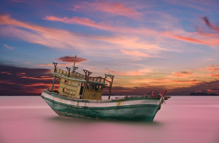 Foto barco de pesca no mar contra o céu durante o pôr-do-sol