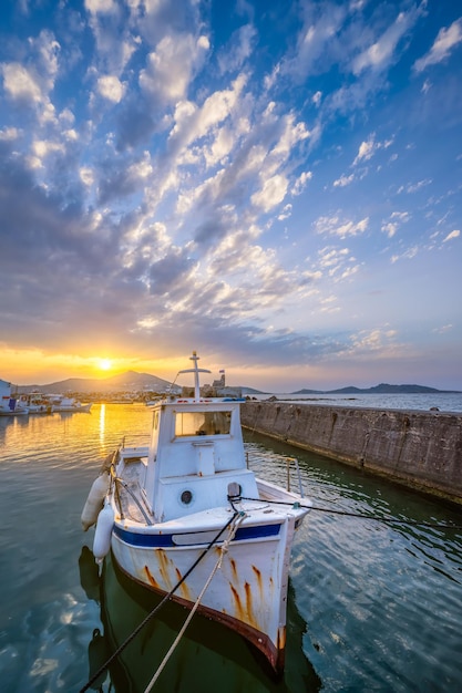 Barco de pesca no porto de Naousa ao pôr-do-sol na ilha de Paros, Grécia