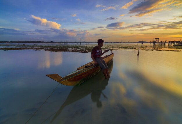 Barco de pesca tradicional em uma vila de pescadores ao pôr do sol na ilha Batam