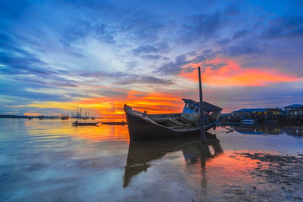 Barco de pesca tradicional em uma vila de pescadores ao pôr do sol na ilha Batam