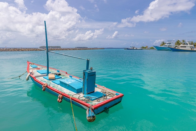 Barco de pesca tropical ao lado da ilha paradisíaca nas Maldivas Ilha local com barcos de pesca de madeira