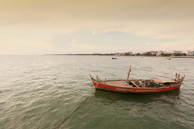 Barco de pesca velho na costa de mar de tailândia.