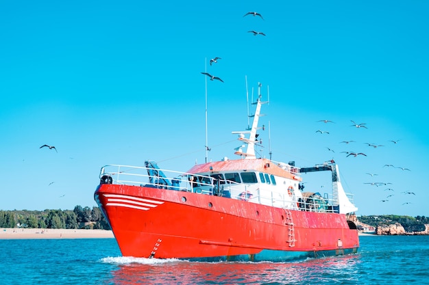 Barco de pesca vermelho ou traineira navegando no oceano atlântico