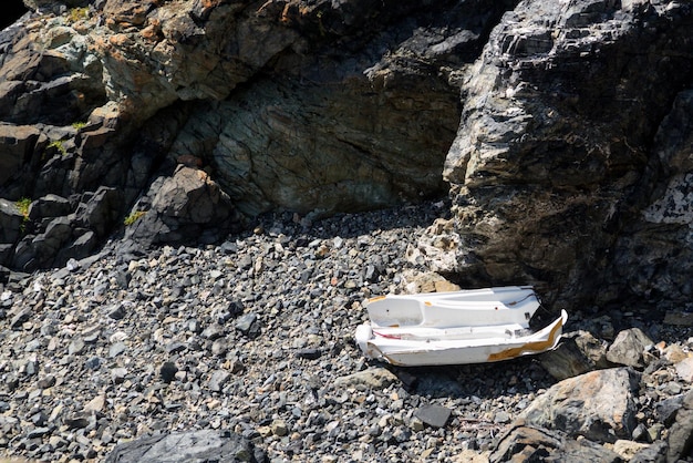 Barco destrozado en la playa rocosa