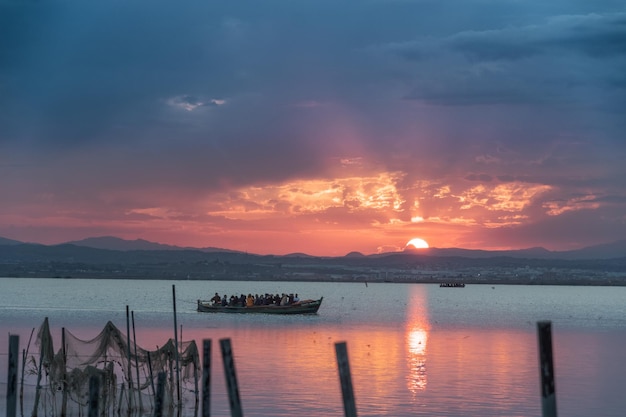 Barco do lago ao pôr do sol laranja fundo cênico do nascer do sol