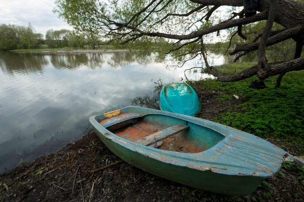 el barco se encuentra a orillas del río en el pueblo de verano