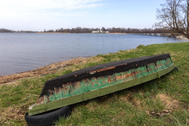 Un barco está sentado en la orilla de un lago.