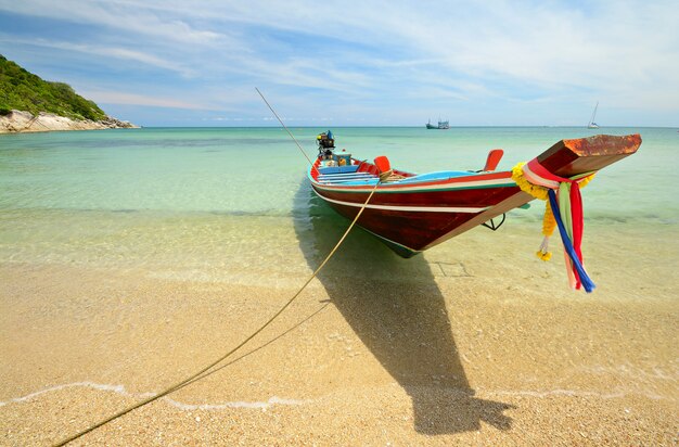 Barco flotando en aguas tropicales transparentes, bote de cola larga en Tailandia