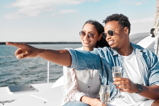 Barco iate e casal com champanhe no sol de verão e mar para celebrar o amor juntos Sorriso feliz de pessoas pela água do oceano ondas azuis e sol na natureza para uma celebração de aniversário