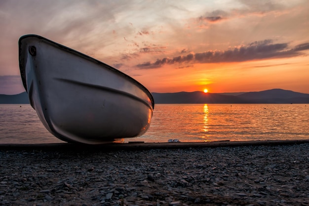 Barco en el lago con el telón de fondo de una pintoresca puesta de sol