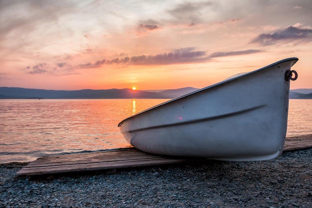 Barco en el lago con el telón de fondo de una pintoresca puesta de sol