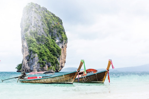 Barco longo e pedras na praia de Railay na Tailândia