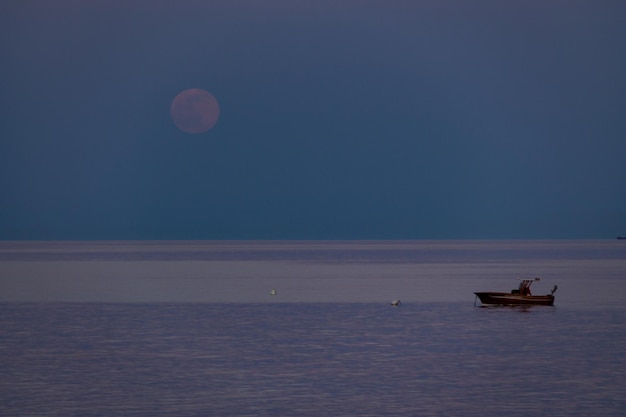 Foto un barco y una luna naciente en una playa mediterránea del mar jónico bova marina calabria italia