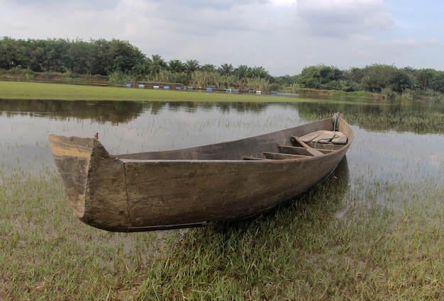 Un barco de madera anclado junto al río.