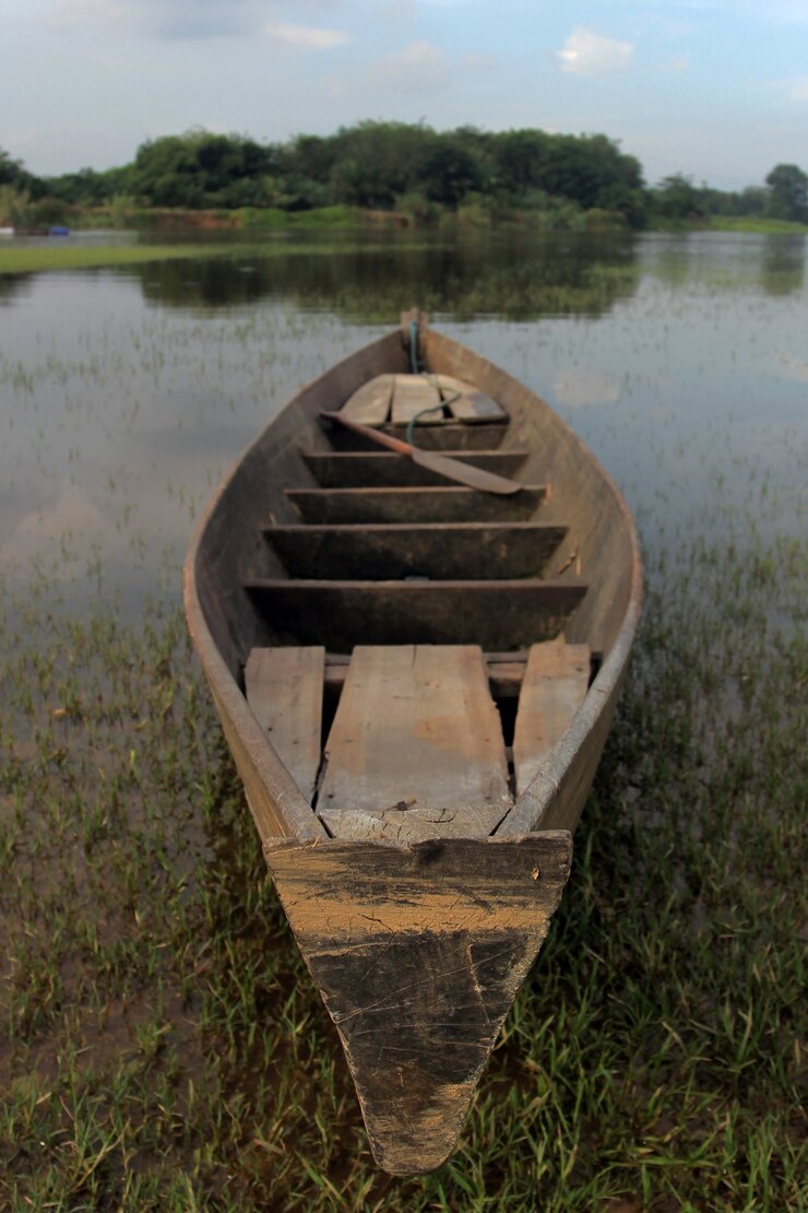 Foto un barco de madera anclado junto al río.