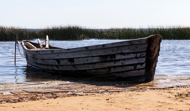 Barco de madera antiguo cerca del lago, utilizado por la población local para pescar, barco en mal estado