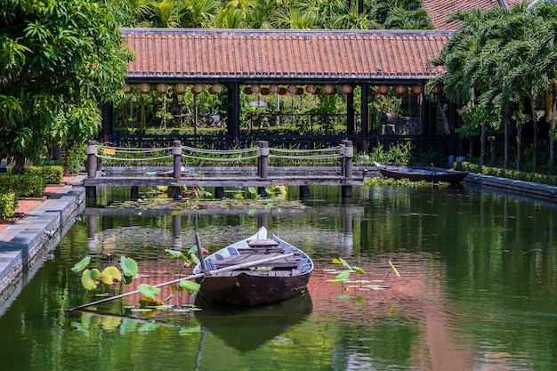 Barco de madera en el estanque cerca del muelle en un jardín tropical en Danang Vietnam