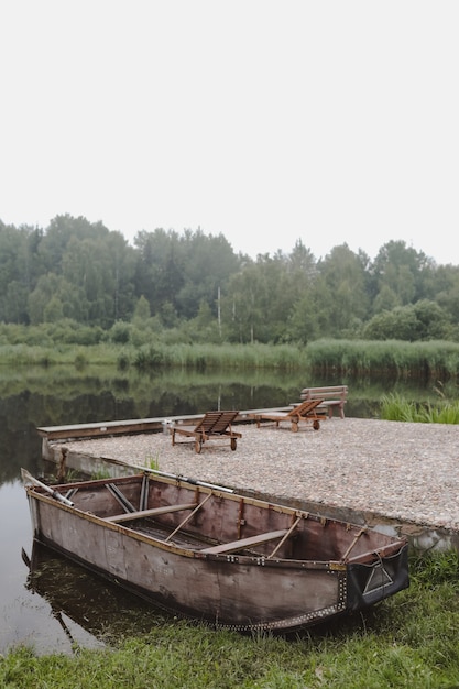 Barco de madera por el muelle en el lago.