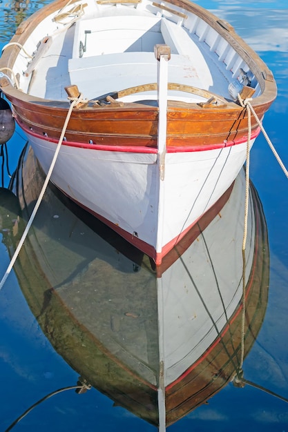 Barco de madera reflejado en el mar