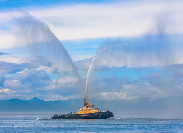 Barco mangueira de incêndio borrifando água em Kamchatka, no oceano Paciic