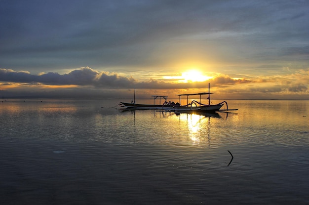 Barco en el mar al amanecer.